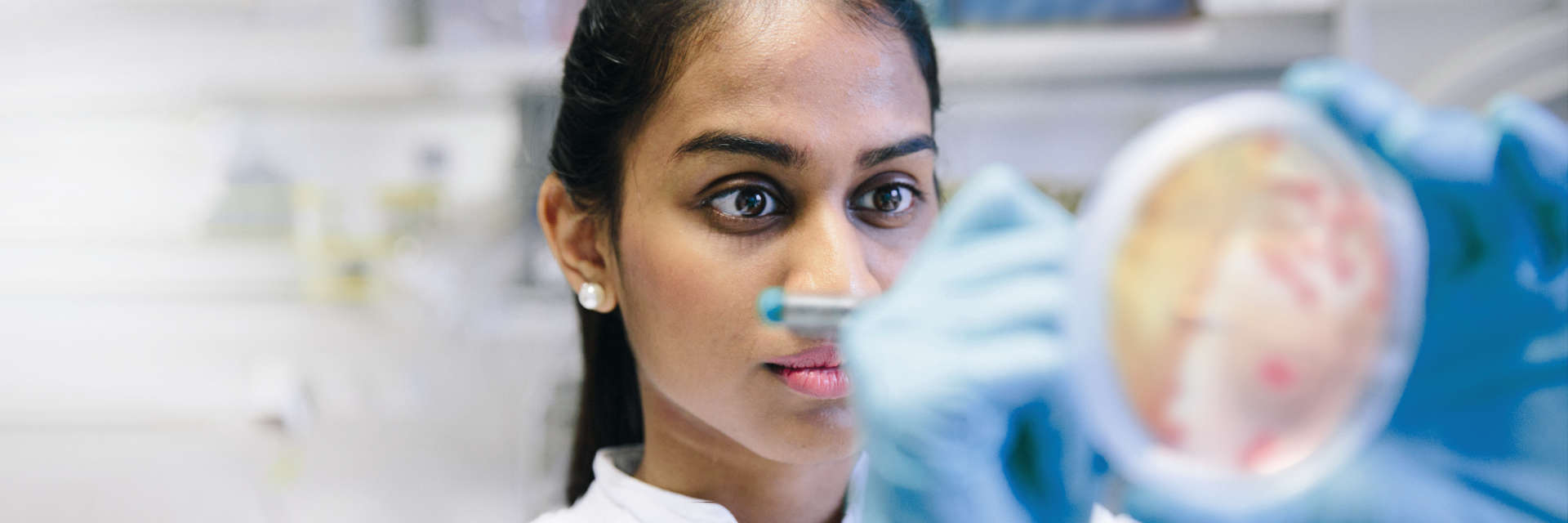 Female Scientist writing on Petri dish